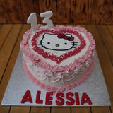Handcrafted Hello Kitty cake with edible decorations, pink bow, and custom sponge, made in North London patisserie