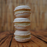 Hands piping smooth macaron batter in a baking class