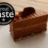 Discover our award-winning Peanut Praline Cake, layered with chocolate ganache, nutty sponge, praline crunch, and caramelised peanut brittle. Collection only from North London.