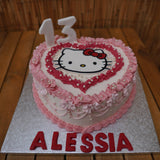 Handcrafted Hello Kitty cake with edible decorations, pink bow, and custom sponge, made in North London patisserie