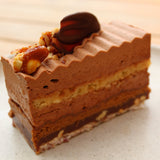 Discover our award-winning Peanut Praline Cake, layered with chocolate ganache, nutty sponge, praline crunch, and caramelised peanut brittle. Collection only from North London.