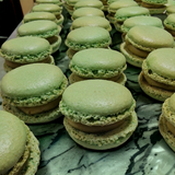 Box of 24 pistachio and rose macarons with almond shells, white chocolate ganache and floral filling, handmade in North London