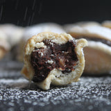 Bite-sized Romanian walnut cookies with rum, chocolate and walnut filling, arranged as elegant canapés for events, made in North London bakery