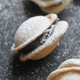 Bite-sized Romanian walnut cookies with rum, chocolate and walnut filling, arranged as elegant canapés for events, made in North London bakery