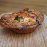 Golden shortcrust salmon and broccoli quiches with creamy filling, handmade in North London bakery and served in sets of four
