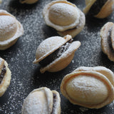 Handmade Romanian walnut-shaped cookies with buttery biscuit shells and chocolate walnut rum filling, sold in bags of 11 from North London bakery