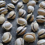 Handmade Romanian walnut-shaped cookies with buttery biscuit shells and chocolate walnut rum filling, sold in bags of 11 from North London bakery