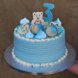 Custom baby celebration cake with pastel decorations, fondant baby toppers, and soft sponge layers, handmade in North London for showers or birthdays