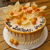 Elegant custom cake featuring passion fruit glaze and handmade chocolate decorations