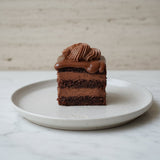 Amandina Romanian chocolate cake slice with rum syrup and chocolate fondant handmade in London