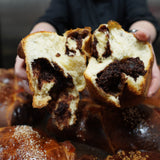 Traditional Romanian Cozonac sweet bread with a cocoa, orange zest and Turkish Delight filling, sliced to reveal its marbled interior by Prestige Patisserie