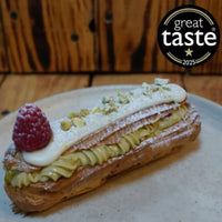 Pastry with raspberry and cream on a plate, featuring the Great Taste 2025 logo.
