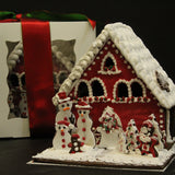 Luxury Christmas gingerbread house centrepiece wrapped in a festive bow.