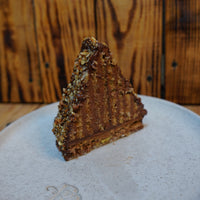 Mountain Cake with pecan and almond jaconde sponge layered with Belgian chocolate mousse. It's coated in honey chocolate ganache, handcrafted in North London