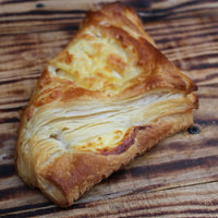 Freshly baked cheese puffs with golden, flaky layers on a baking tray