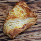 Freshly baked cheese puffs with golden, flaky layers on a baking tray
