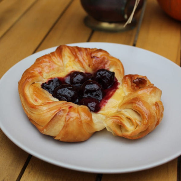 Set of four golden cherry Danish pastries with vanilla custard and dark cherries, handmade with 100% butter in North London bakery