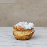Choux à la Crème pastry filled with vanilla crème pâtissière and topped with cream cheese frosting, handcrafted in North London