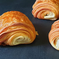 Four handmade Pain au Chocolat pastries with crisp, golden layers and Belgian chocolate filling, baked fresh in North London
