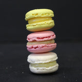Box of 24 handmade passion fruit macarons with crisp almond shells and tropical ganache filling, flourless and freshly made in North London