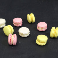 Box of 24 handmade passion fruit macarons with crisp almond shells and tropical ganache filling, flourless and freshly made in North London